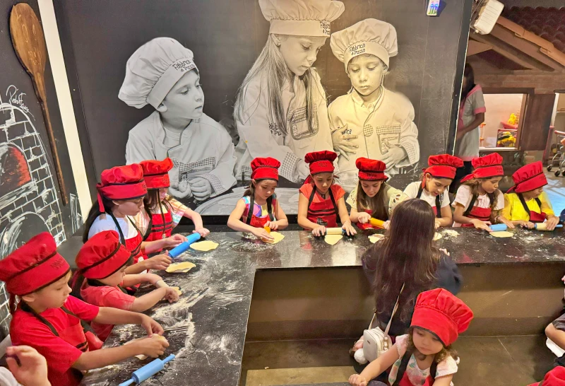 Crianças preparando pizza na brinquedoteca da Fabbrica di Pizza, restaurante com espaço infantil em Goiânia