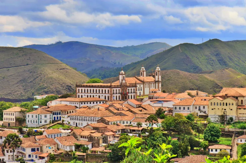 Foto panorâmica de Ouro Preto em Minas Gerais, com igrejas barrocas, casarios coloniais e montanhas ao fundo — destino ideal pra onde viajar em setembro no Brasil