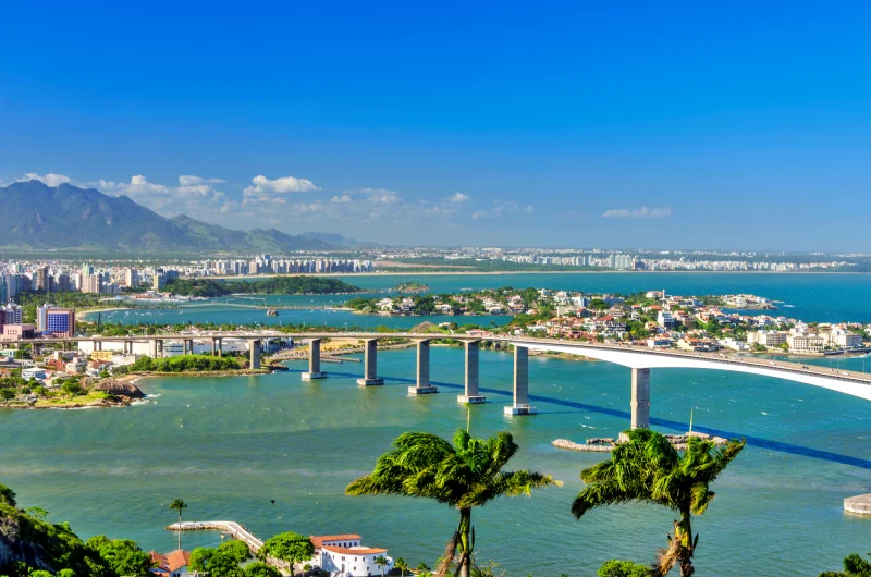 Vista da ponte em Vitória no Espírito Santo com o mar ao fundo em dia ensolarado, um destinos perfeito para viajar em setembro no Brasil