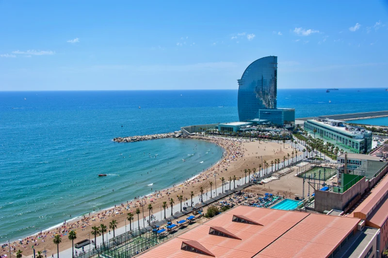 Praia de Barcelona com turistas aproveitando o sol durante o verão na Europa