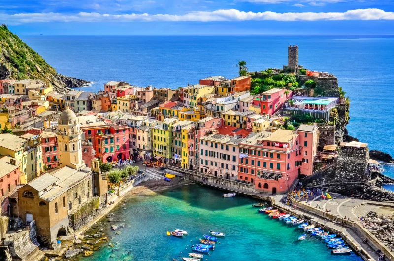 Vista panorâmica de Cinque Terre com casas coloridas sobre falésias e o mar azul ao fundo