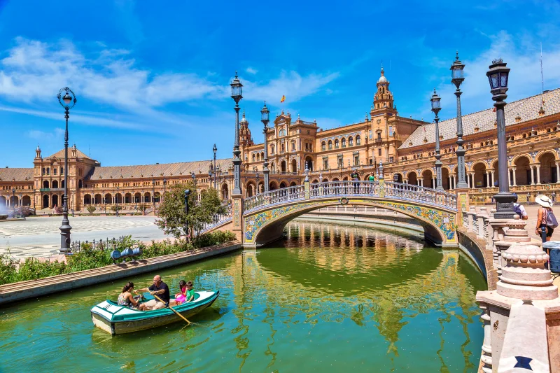 Família com crianças passeando de barquinho na Plaza de España em Sevilha, um dos melhores destinos da Espanha para crianças