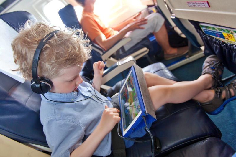 Criança viajando de avião com IPAD